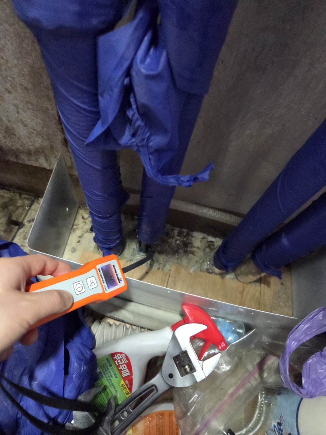 보온재로 감싼 배관 주변을 가스 감지기로 점검하는 모습
